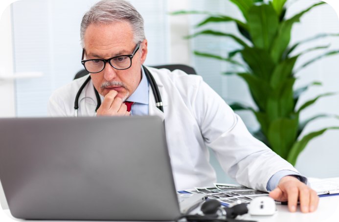 Physician reviewing billing information on a laptop