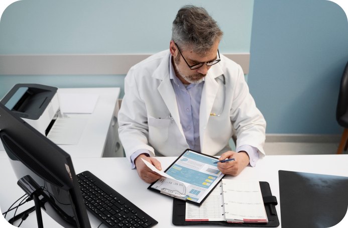 Physician reviewing a billing report on a tablet at his desk